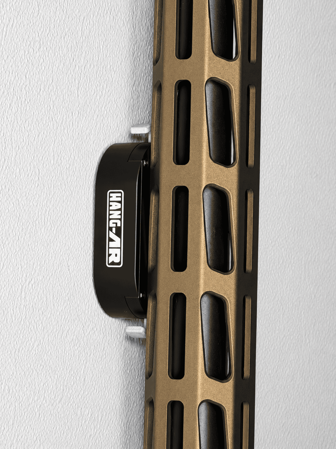 Close up of tan rifle displayed vertically on a wall using a Hang-AR Quick-Detach STEALTH M-LOK mount